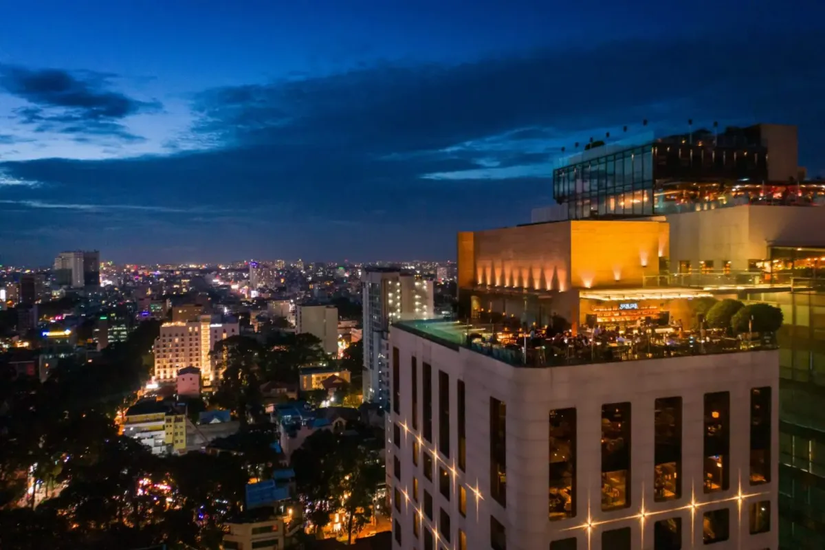 日暮れのホーチミンの夜景に浮かぶHôtel des Arts 24階のソーシャルクラブ ルーフトップ